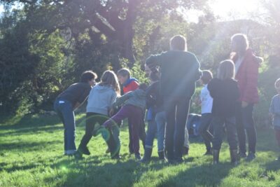 Enfants et parents faisant une animation de plein air en vacances à la ferme